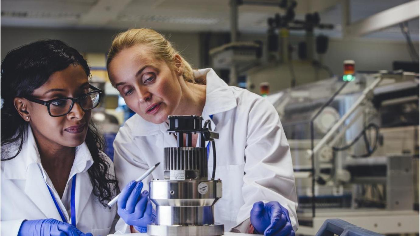 Two female medical engineers examining a piece of equipment.