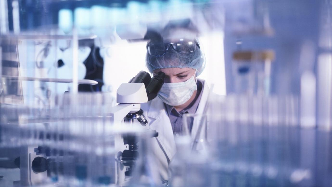 Researcher examining a sample through a microscope