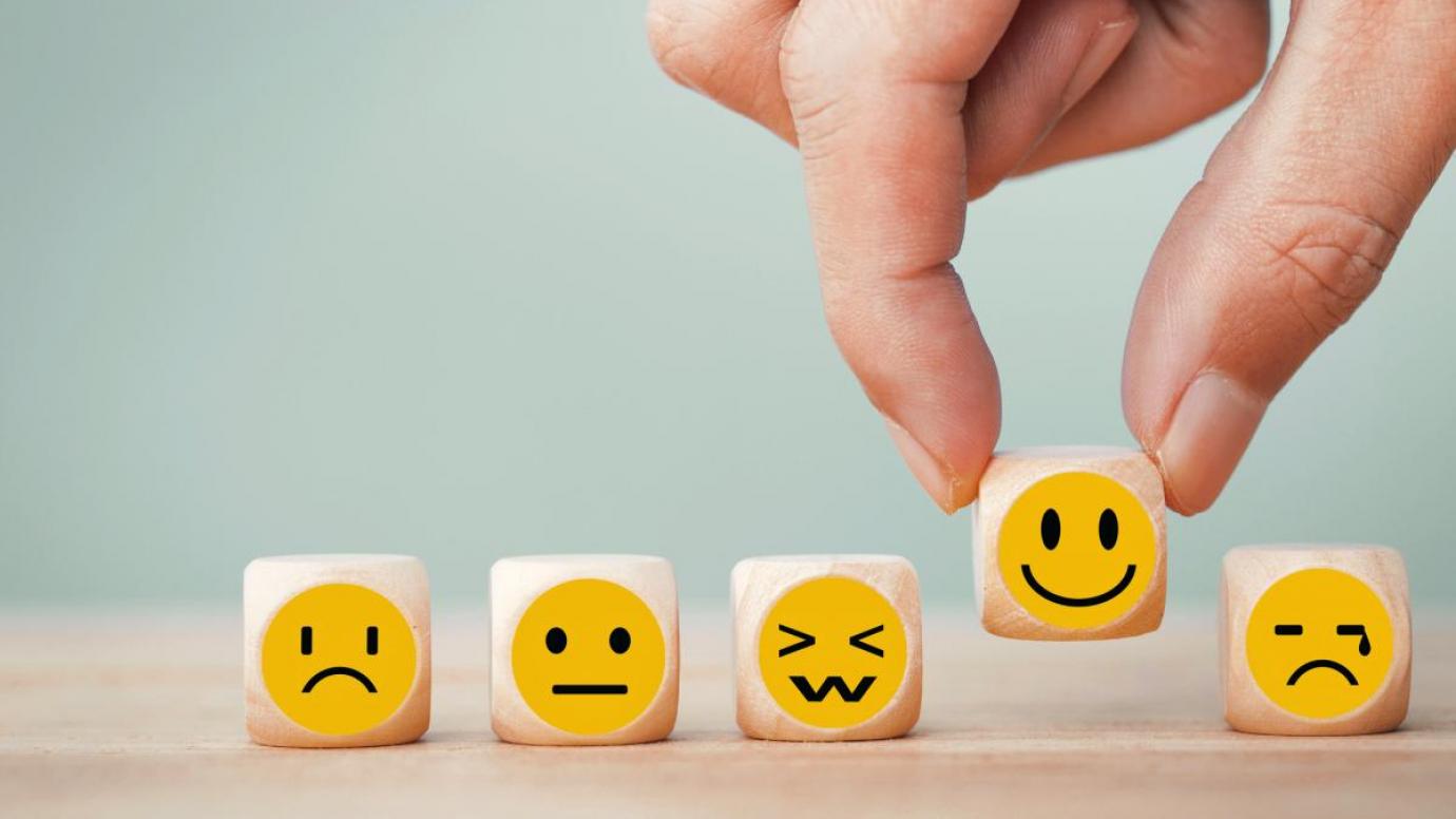 A person handles tokens indicating happiness