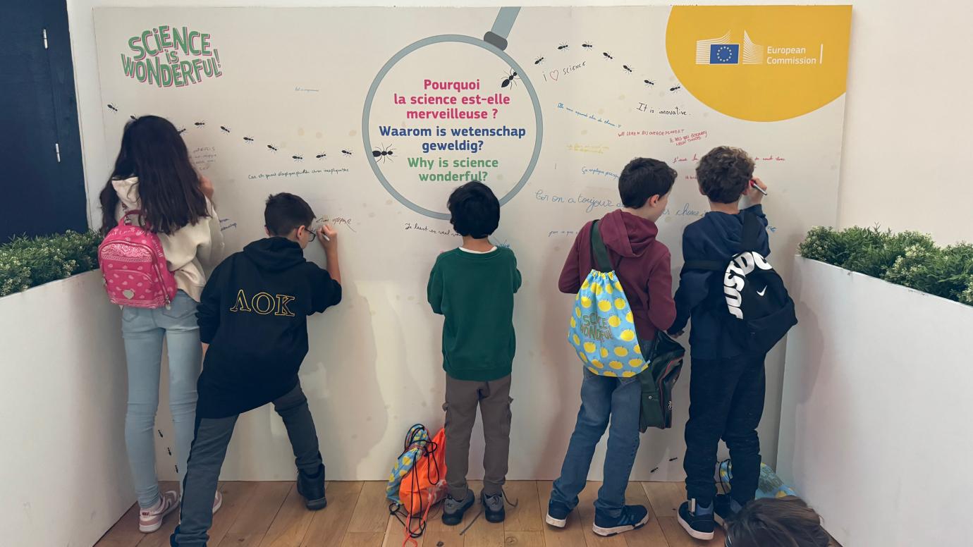 five children answering in writing on the board to the question Why is science wonderful?